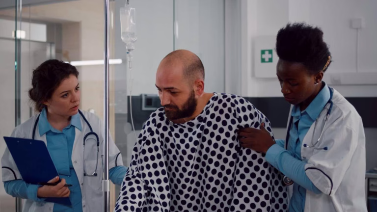 physician-doctors-helping-patient-stand-up-from-bed-holding-intravenous-iv-fluid-drip-bag (1)