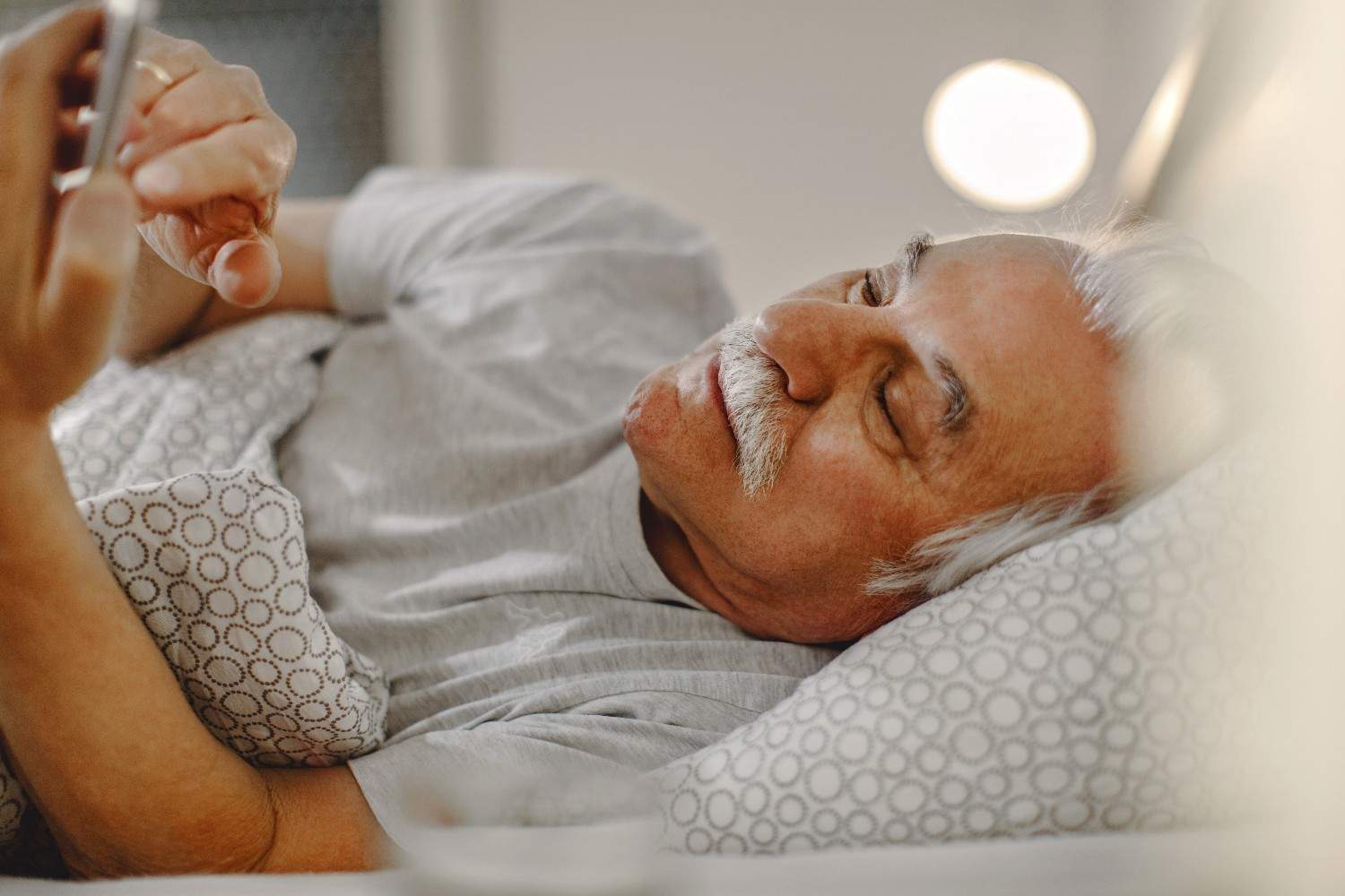 mature-man-text-messaging-mobile-phone-while-lying-down-bed (1)