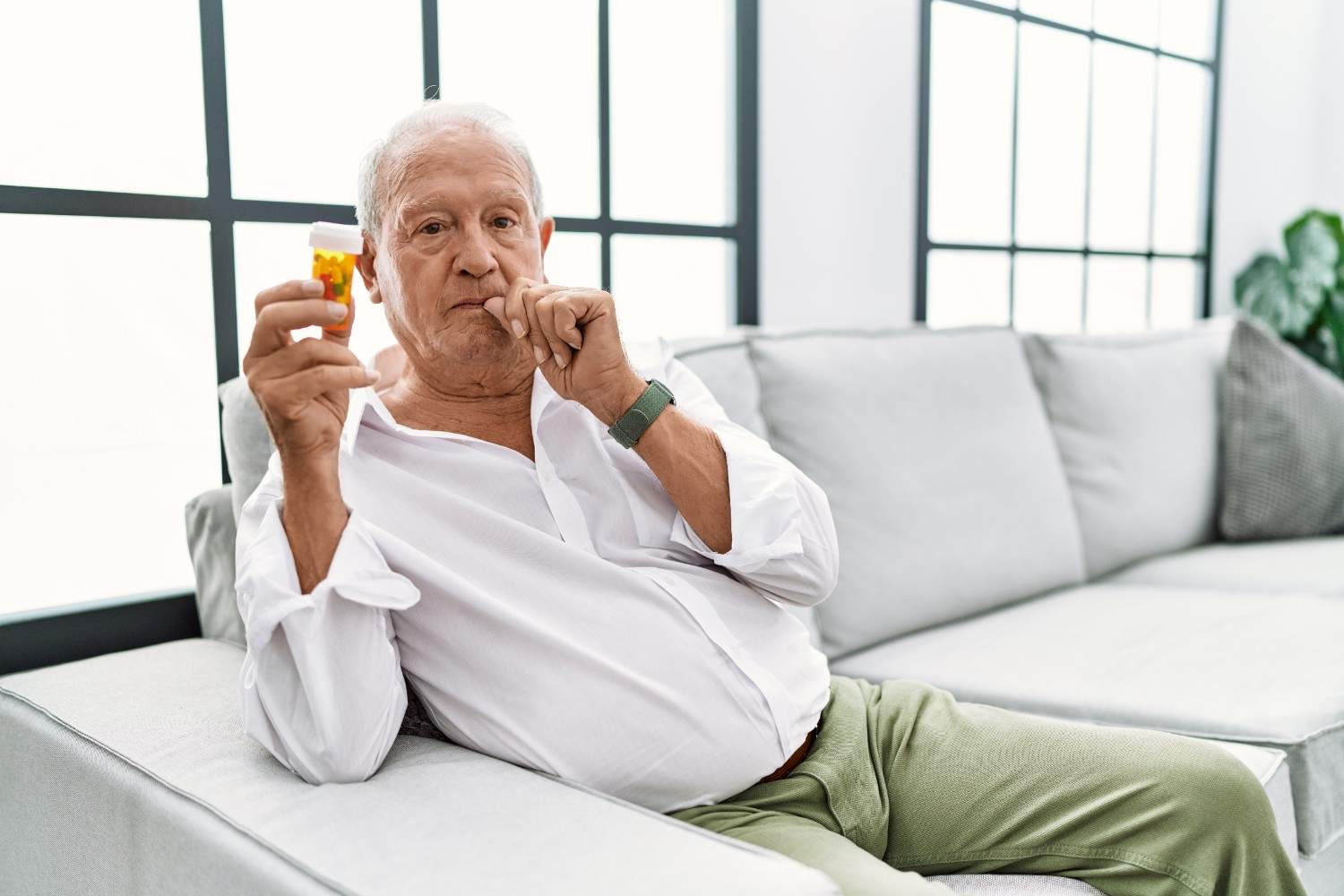 senior-man-holding-pills-mouth-lips-shut-as-zip-with-fingers-secret-silent-taboo-talking (1)